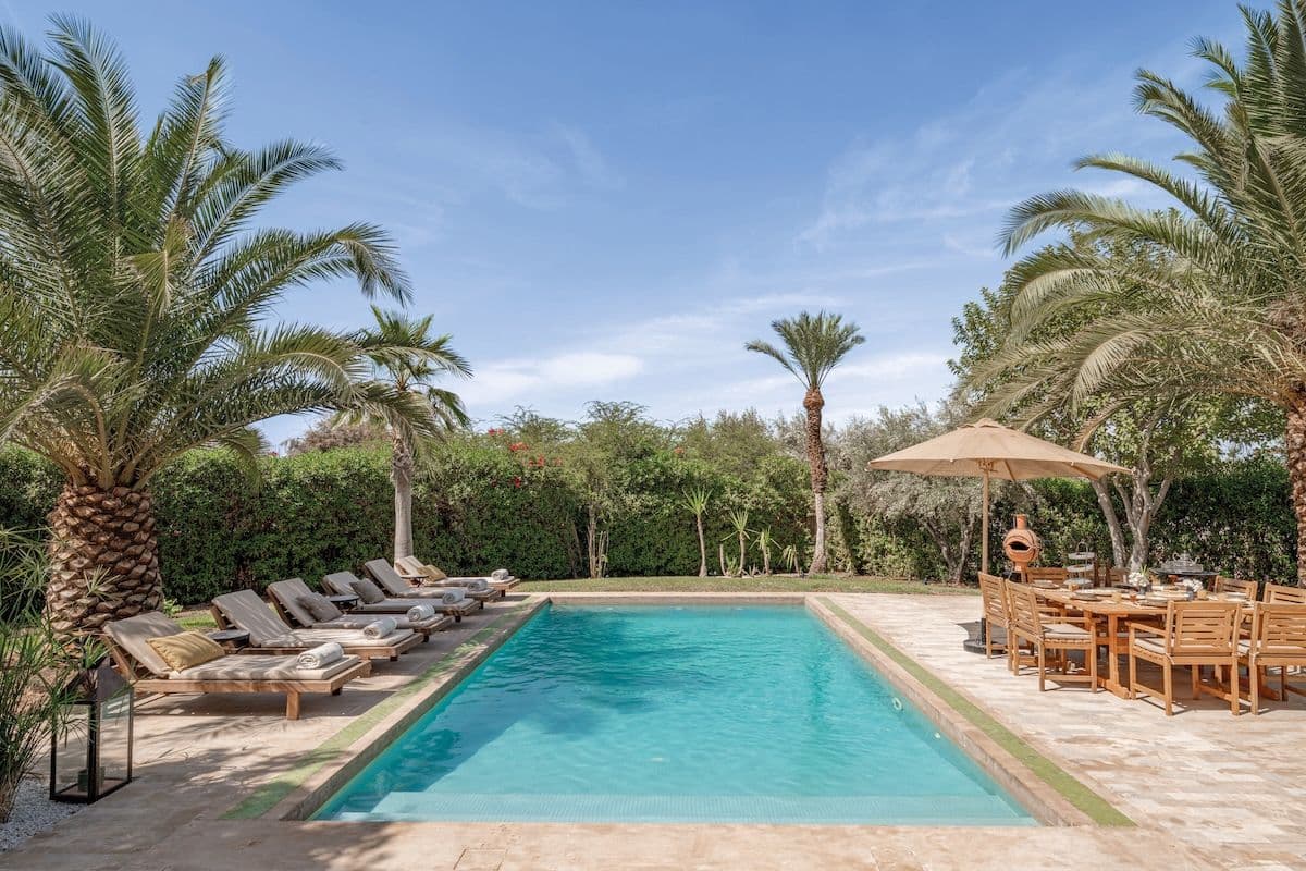 Piscine Villa Aima entourée de palmiers et transats Marrakech